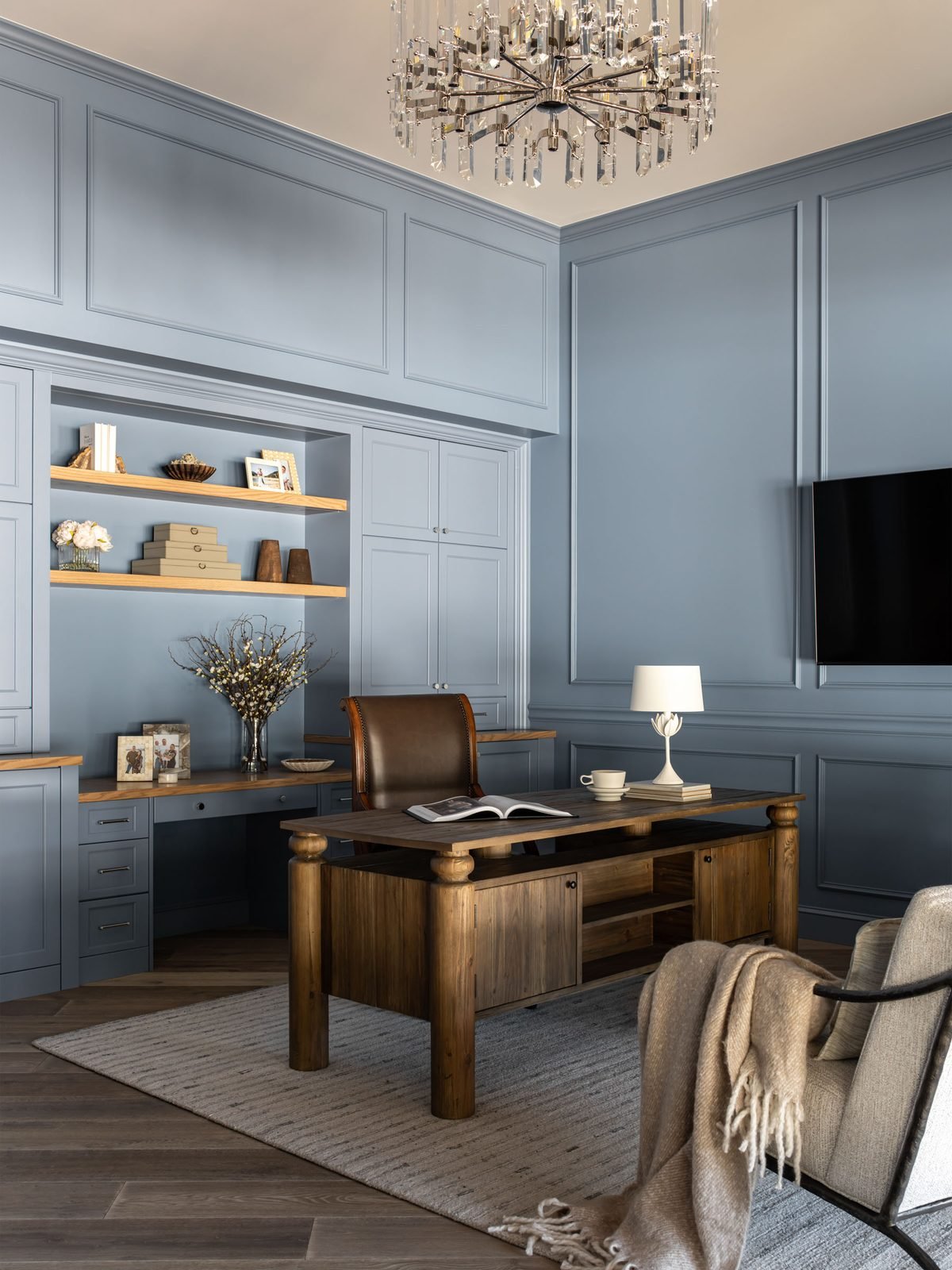 Home office with slate-blue paneled walls and leather chair
